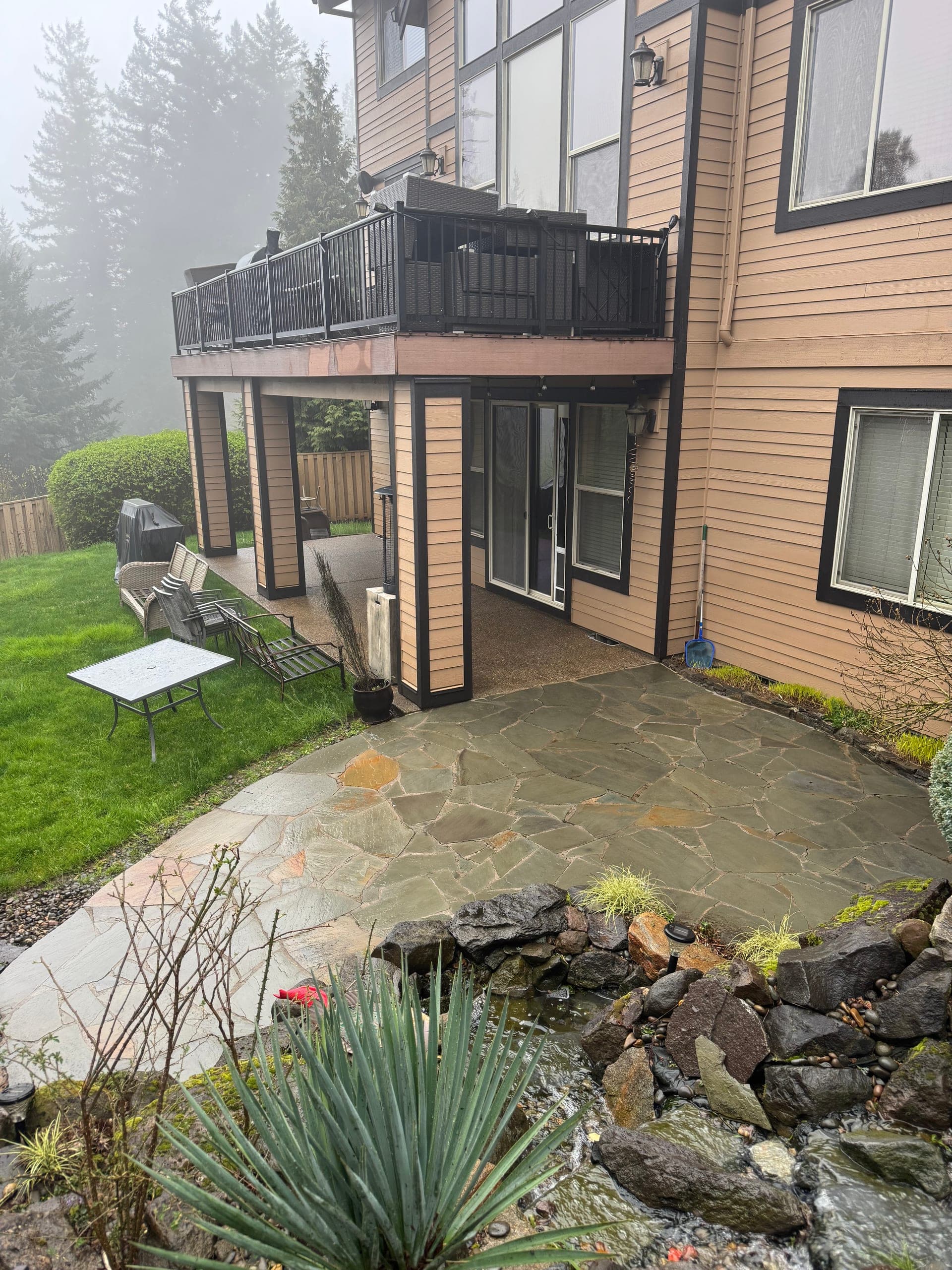 Flagstone patio dark with grime and organic buildup before cleaning.